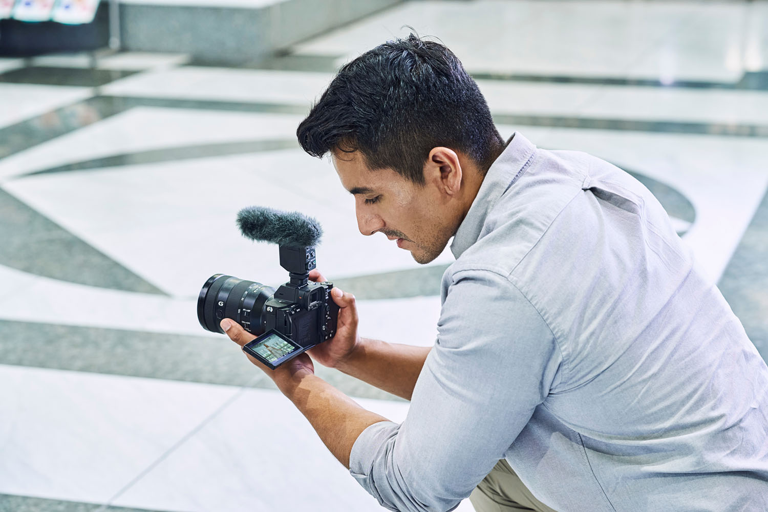Sony Alpha 7 IV mit Mikrofon im Einsatz für Videoaufnahme, Kamerabedienung über ausgeklapptes Display