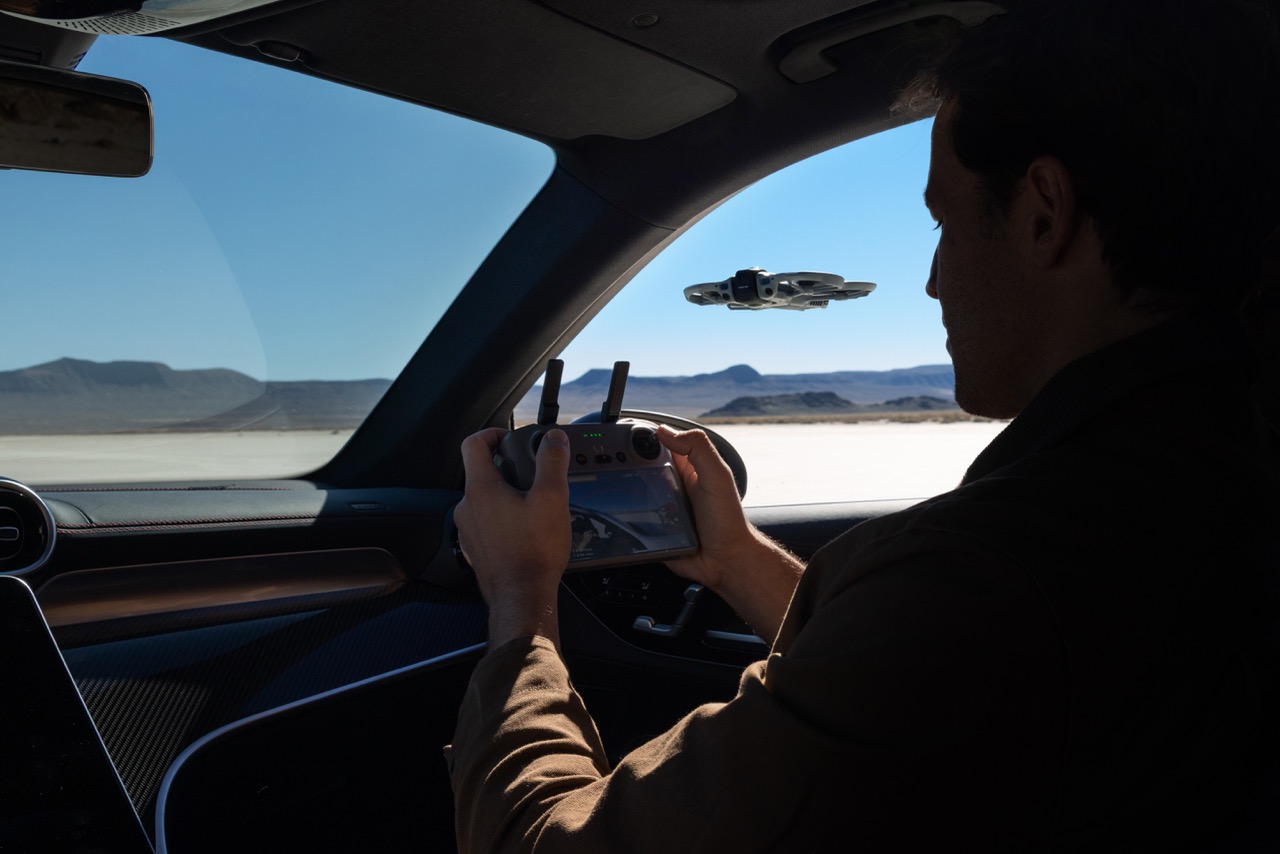 DJI Avata 360 Drohne wird per Controller aus dem Fahrzeuginnenraum in offener Landschaft gesteuert
