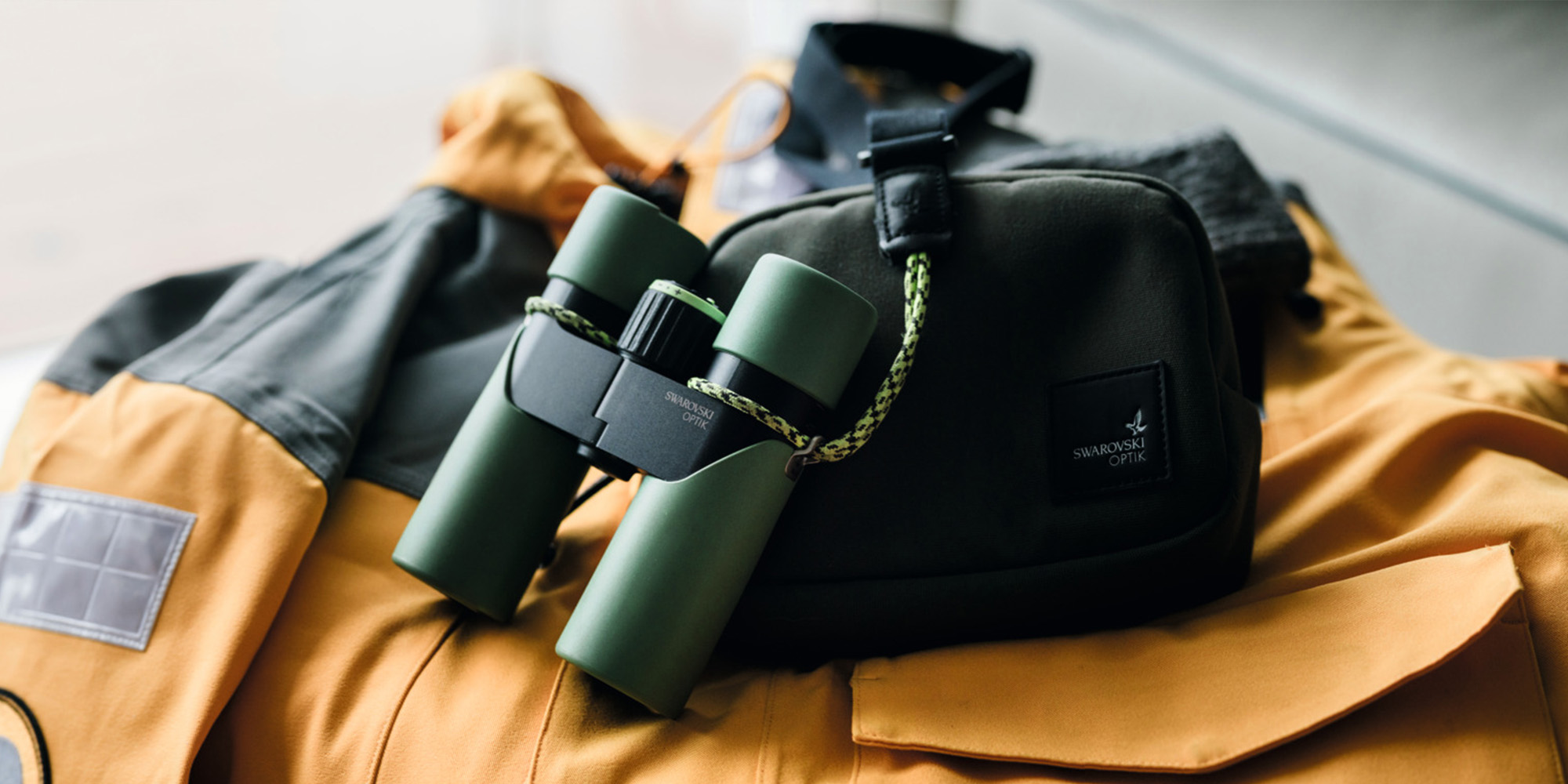 Swarovski Optik CL Companion III Fernglas mit Tragetasche auf Outdoor-Jacke in naher Detailansicht