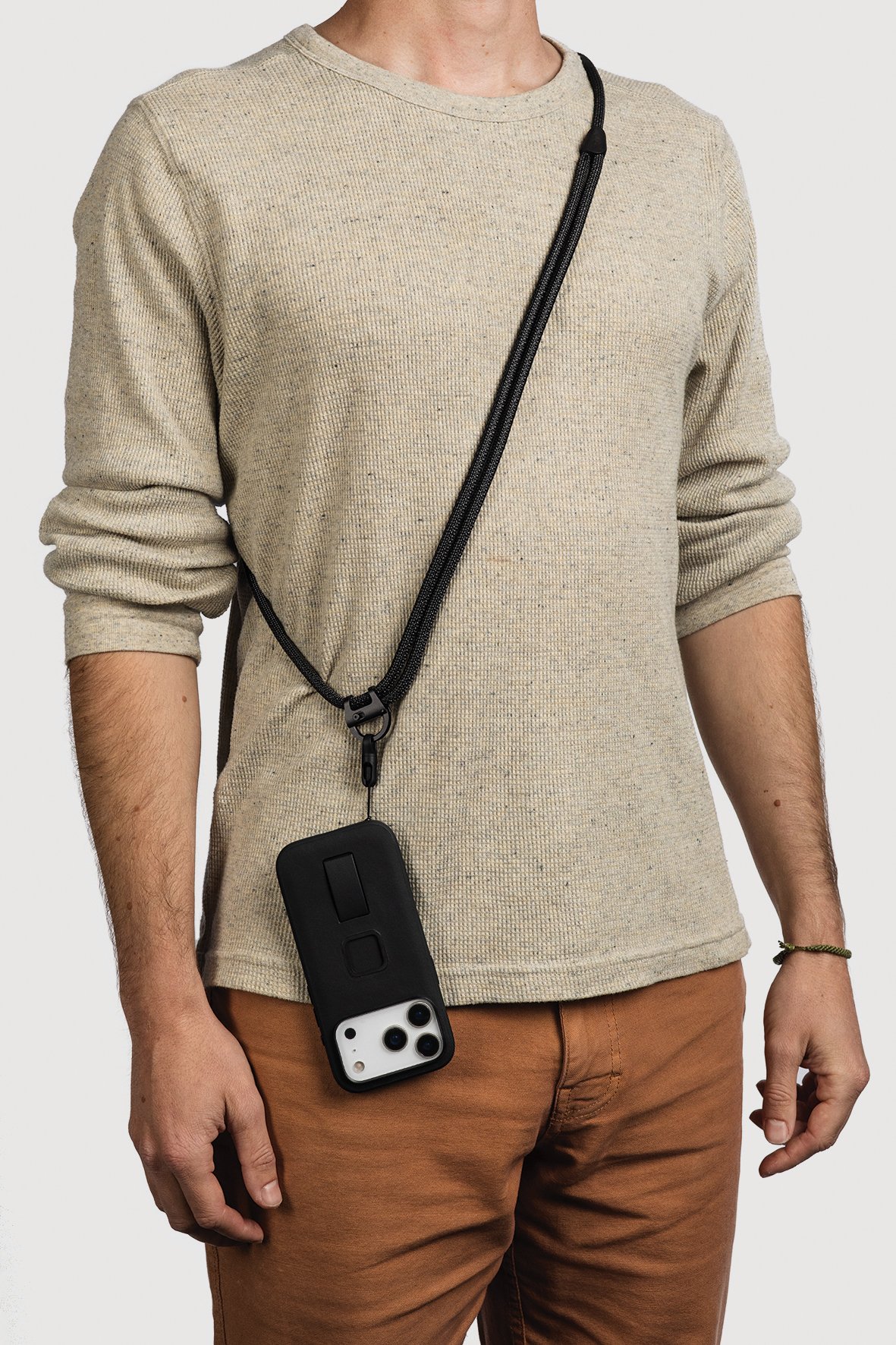 Peak Design Mobile Crossbody Multi-Strap in Schwarz als Umhängeband mit Smartphone im praktischen Trageeinsatz.