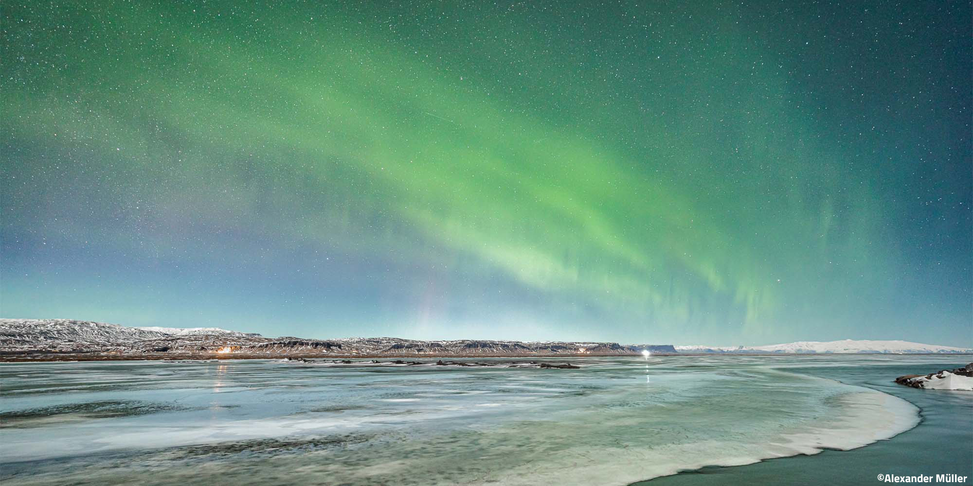 Canon RF 14mm F1.4 – Nordlichter über ruhiger Küstenlandschaft bei Nacht mit klar sichtbarem Sternenhimmel