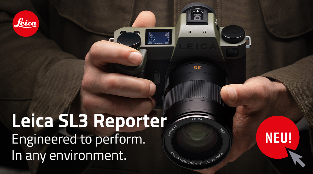 Leica SL3 Reporter in Olivgrün in den Händen eines Fotografen, Nahaufnahme der Frontansicht