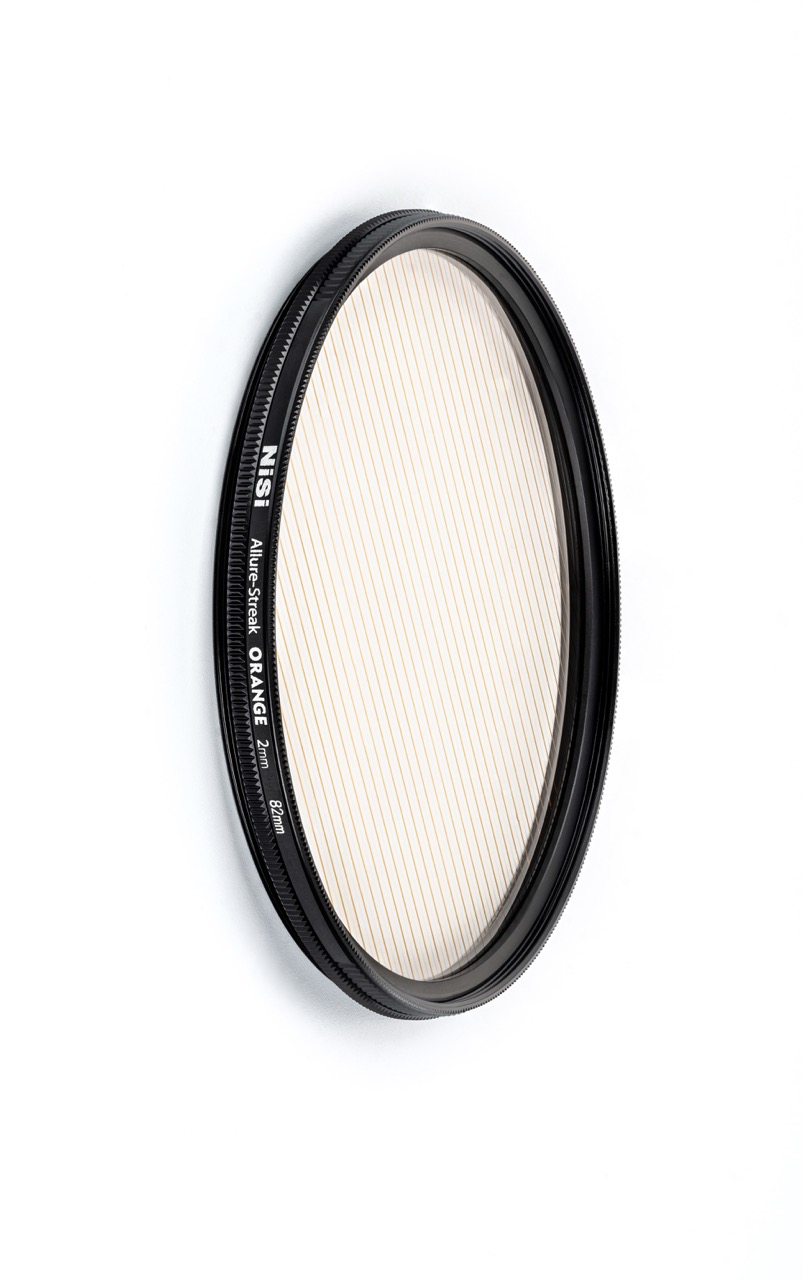 Allure Streak Orange 67mm (2mm Streak) NiSi Allure Streak Orange 67 mm – schräge Ansicht des Kameraeffektfilters mit orangefarbenen Streifen zur Lichtakzentuierung