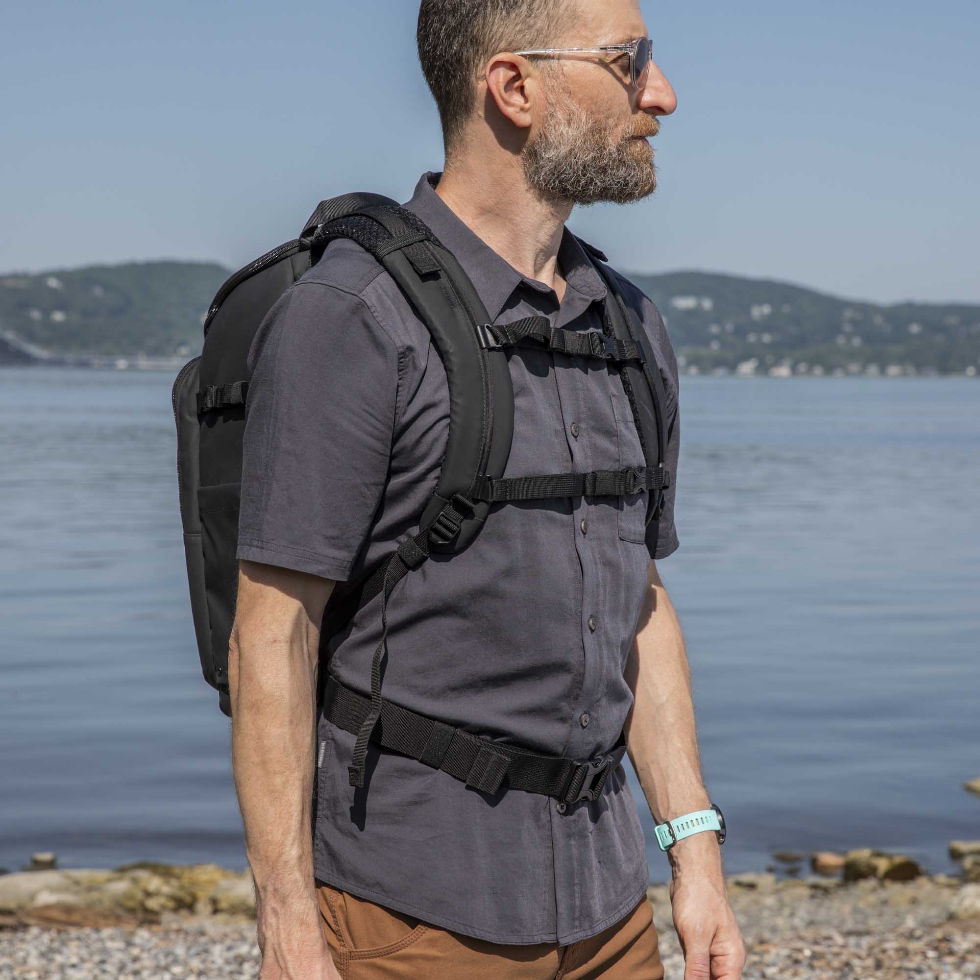 Axis V2 16L Rucksack (schwarz) Tenba Axis V2 16L Rucksack in der Farbe Schwarz, Lifestyle Foto mit Mann vor einem Gewässer