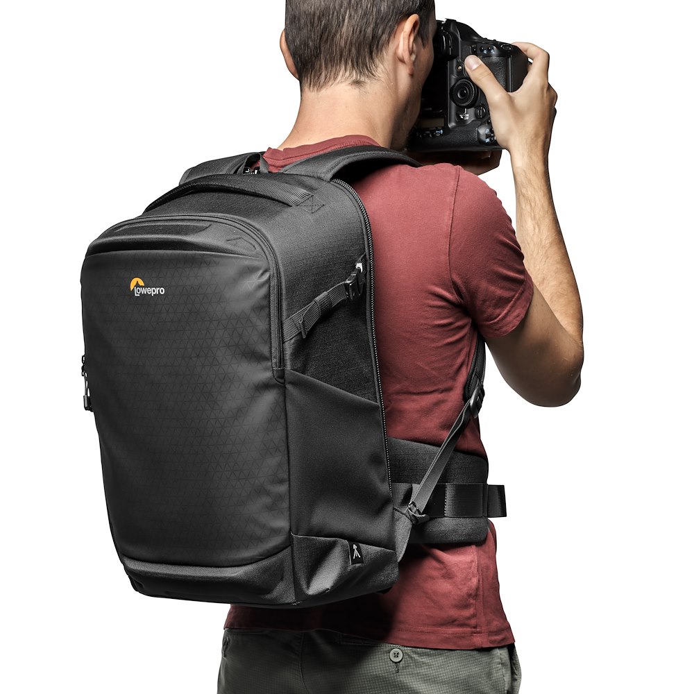 Lowepro Flipside BP 400 AW III in Schwarz, getragen auf dem Rücken eines Fotografen bei der Nutzung mit Kamera