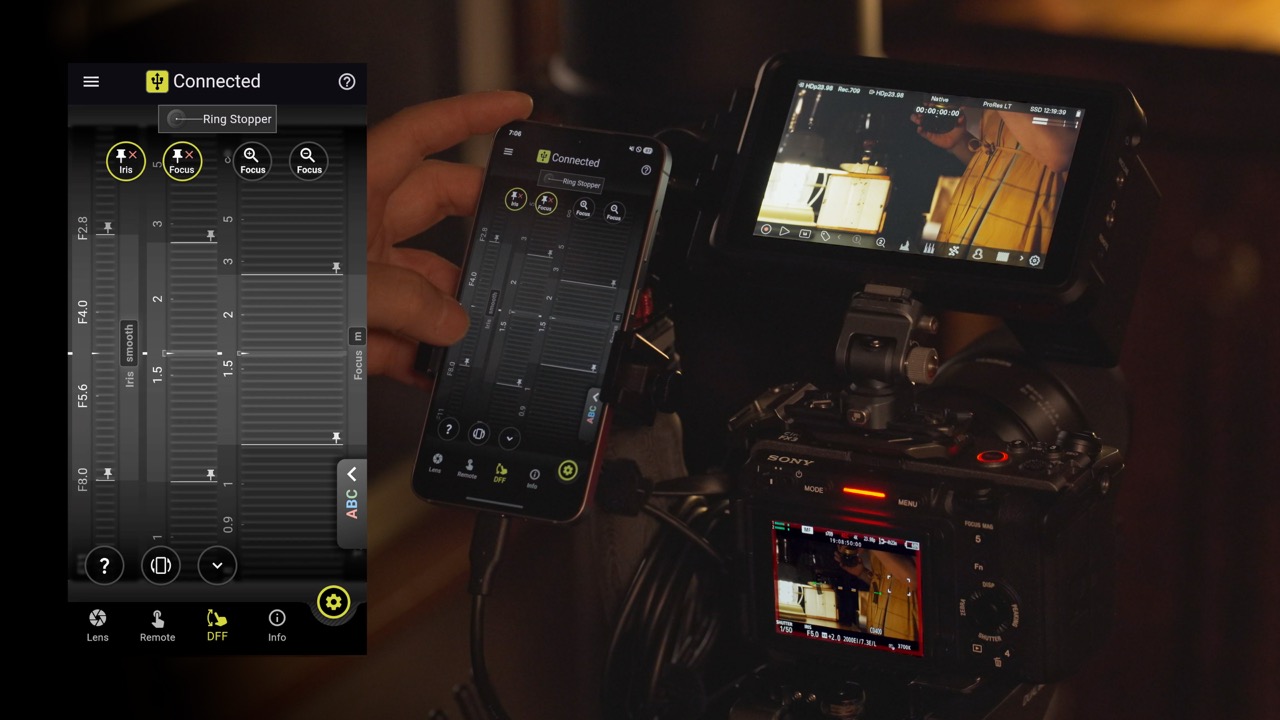 TAMRON Lens Utility mit Ring Stopper auf dem Smartphone, verbunden mit Kamera und externem Monitor bei Innenaufnahme
