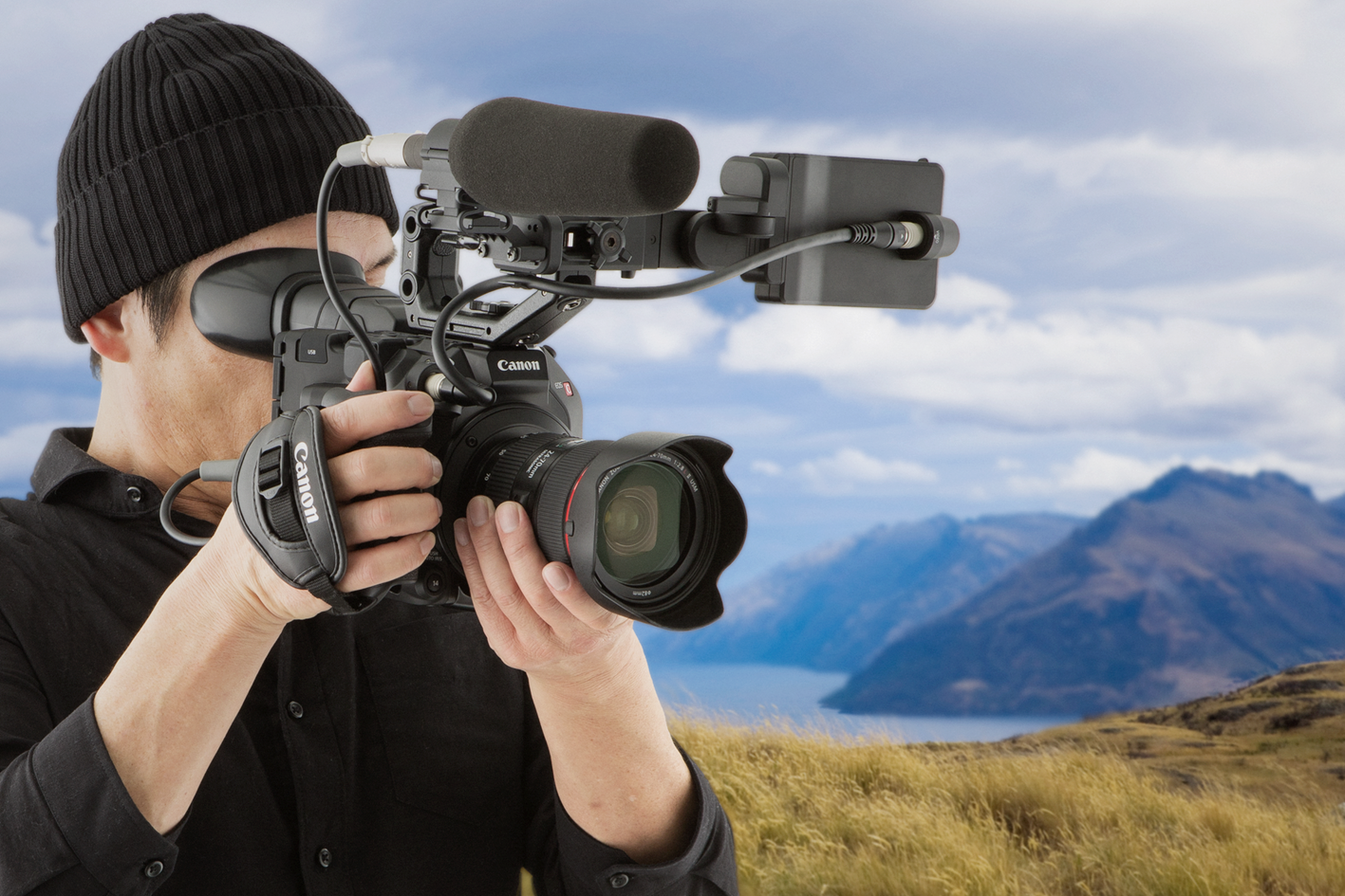 Kameramann filmt mit Canon Cinema-Kamera und externem Mikrofon in Landschaftsumgebung