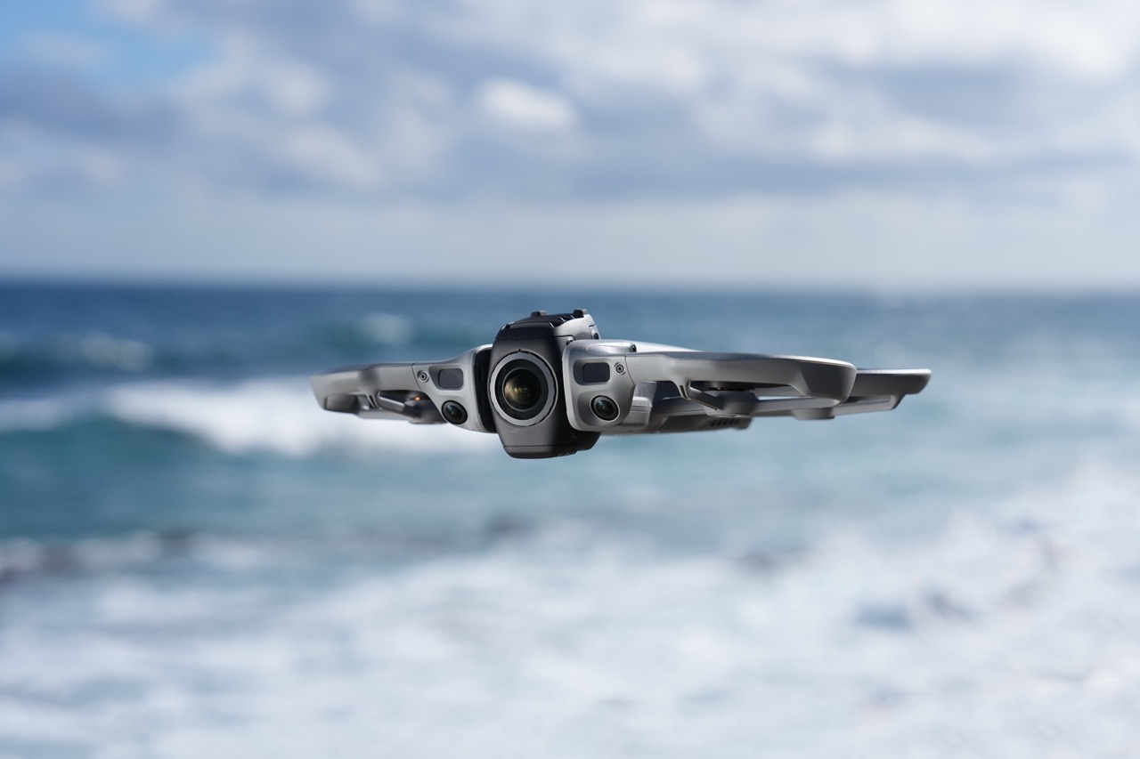 DJI Avata 360 Drohne in Frontansicht im Flug über dem Meer mit sichtbarer Kameraeinheit