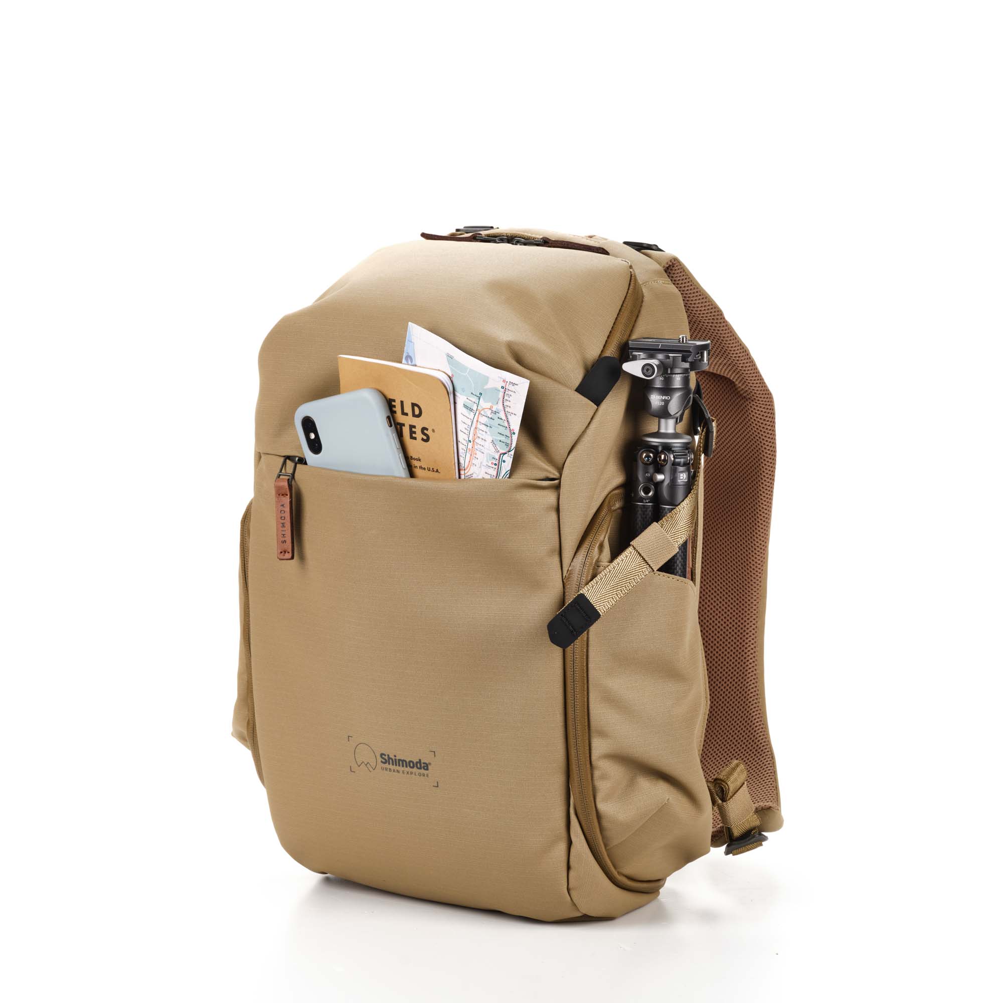 Shimoda Designs Explore 20 Rucksack in Beige, Frontal links mit Smartphone, Field Notes und Karte in Fronttasche und Stativ in der Seitentasche