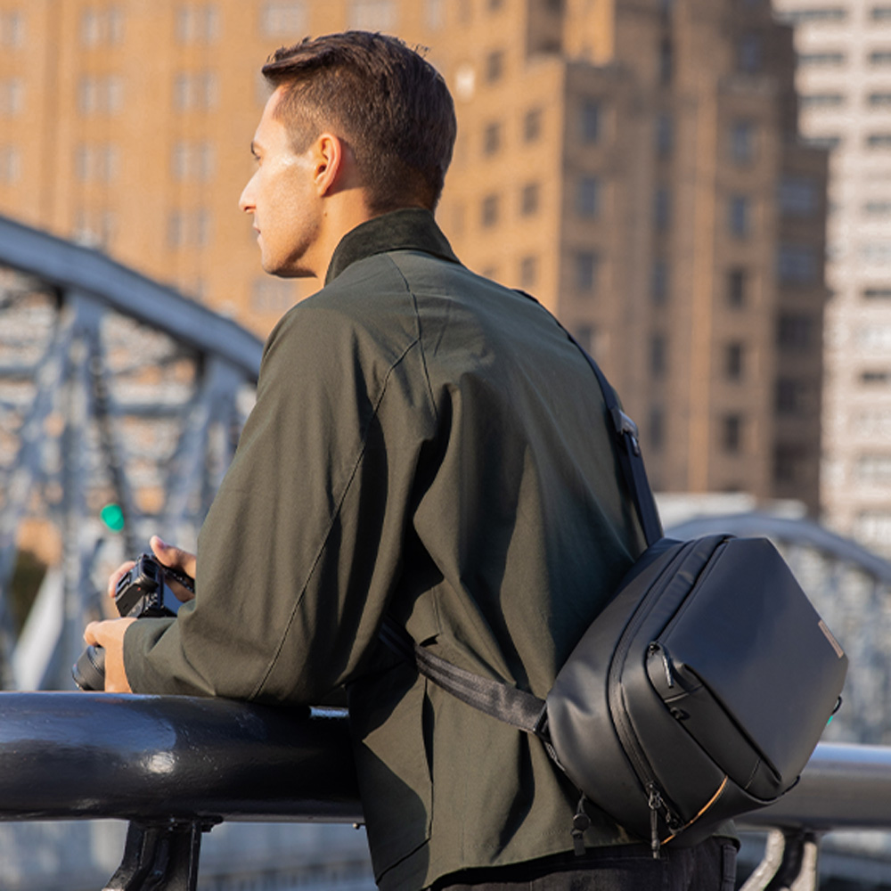 PGYTECH OneGo Solo V2 10L in Obsidian als Sling-Tasche im Einsatz beim Fotografieren im urbanen Umfeld.