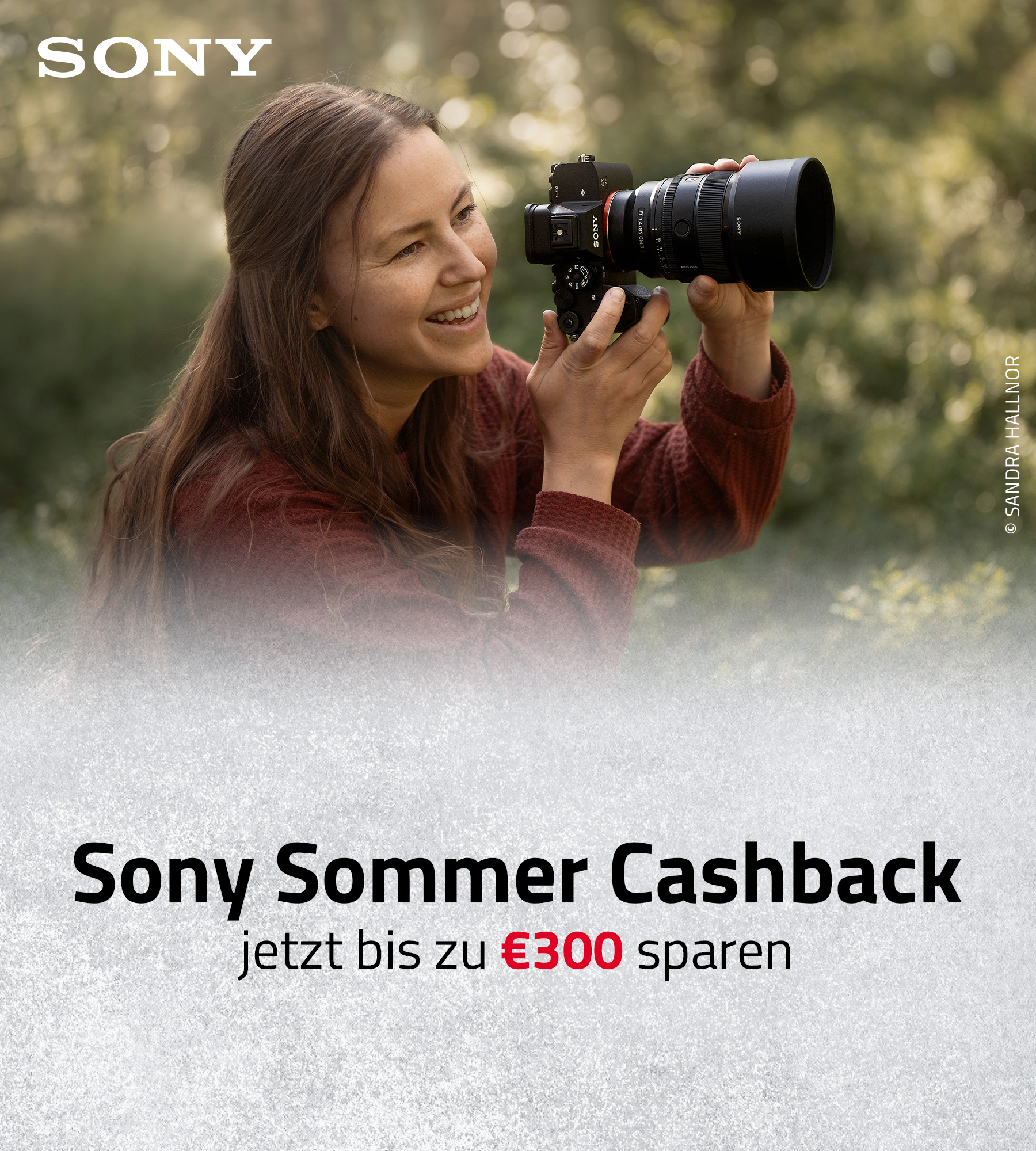 Sony Systemkamera mit Teleobjektiv in Nutzung, Person fotografiert im Freien während Sommer Cashback Aktion