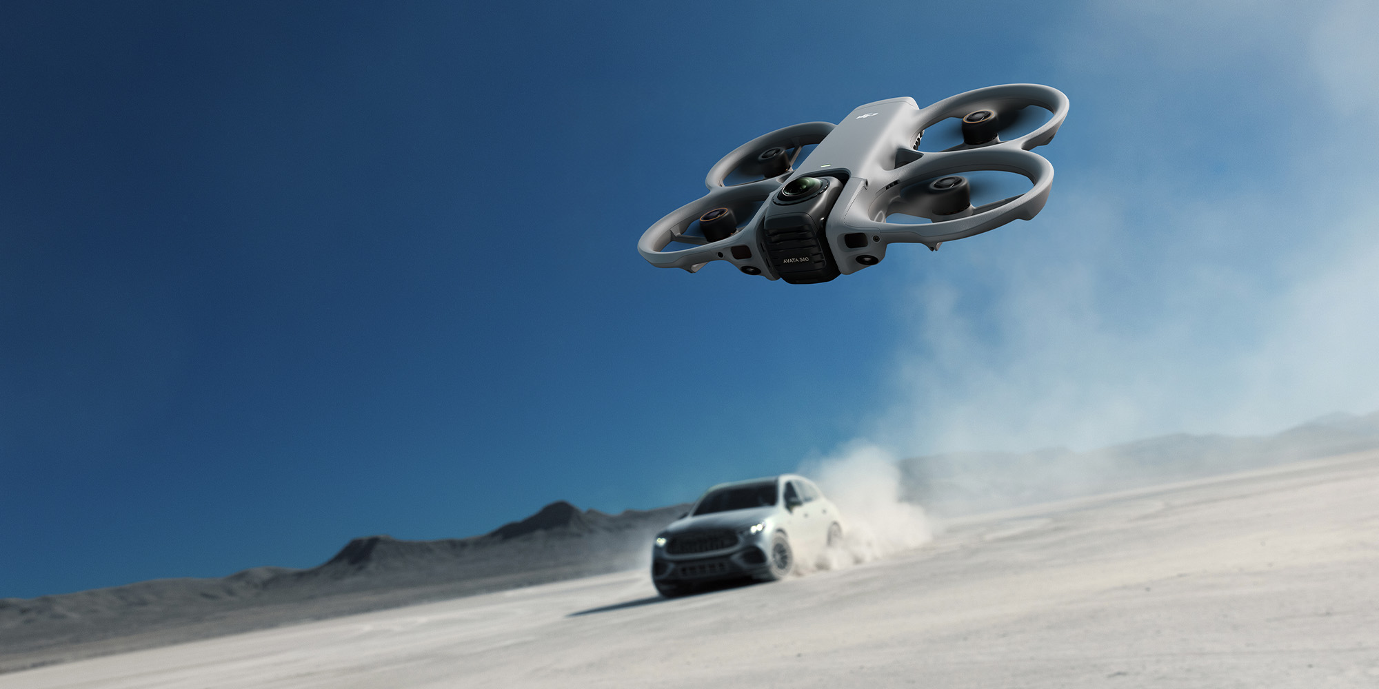 DJI Avata 360 Drohne verfolgt Fahrzeug in Wüste und erzeugt dynamische Flugaufnahme mit Staubwolke