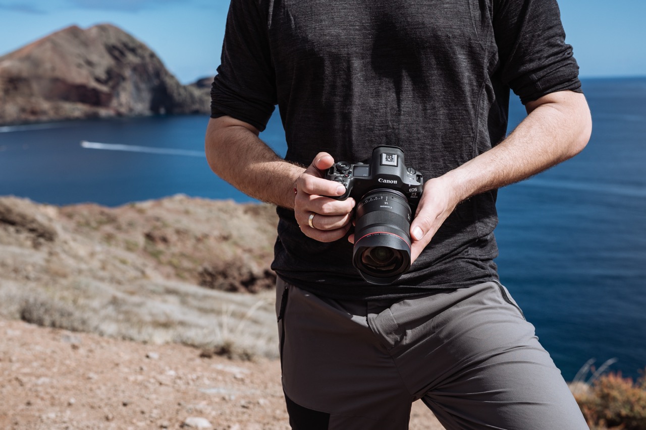 Canon EOS R6 mit RF Objektiv in Händen eines Fotografen bei Küstenlandschaft, Einsatz für Outdoor-Fotografie