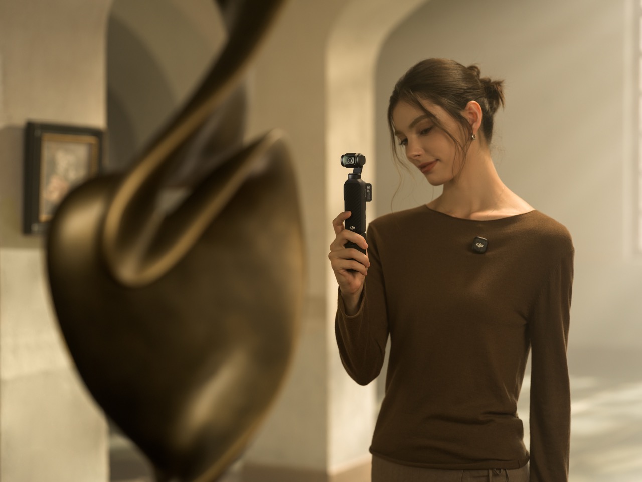 DJI Osmo Pocket 4 – Handheld-Nutzung im Innenraum, Person betrachtet das Gerät bei Videoaufnahme in ruhiger Umgebung