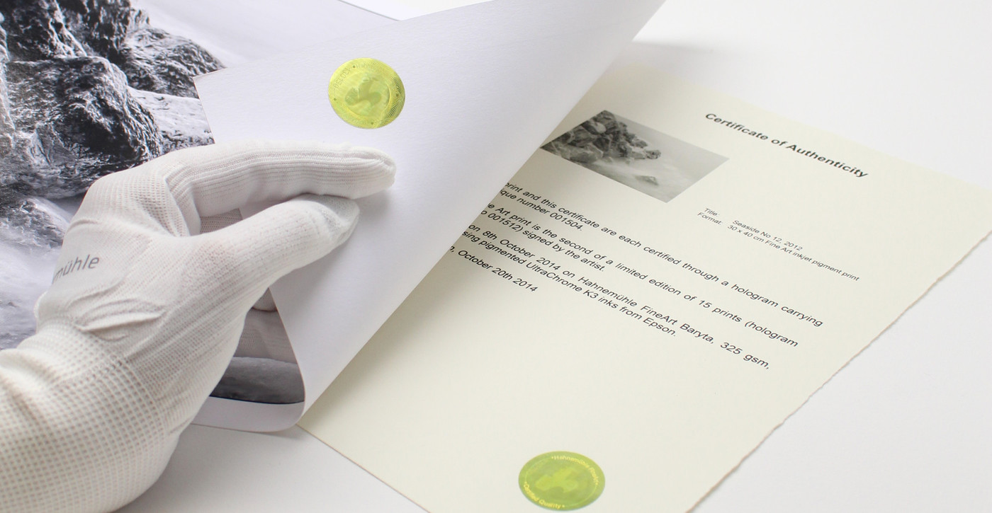Echtheitszertifikat A4 / 25 Blatt Hahnemühle Echtheitszertifikat einmal liegend einmal während dem umblättern durch eine HAnd die vom linken Rand des Bildes hereinrat