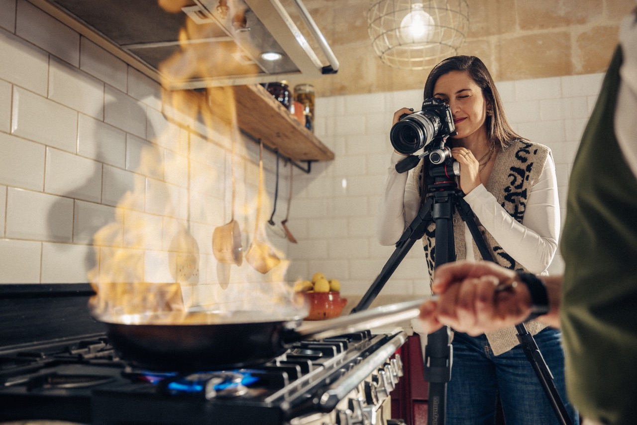 Manfrotto ONE Stativ filmt Kochszene in der Küche mit Flamme am Herd im Vordergrund